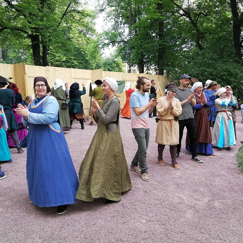 Piiritanssia tanssivia ihmisiä Keskiaikaisilla markkinoilla